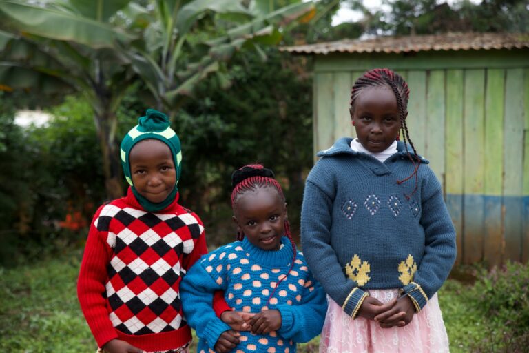 three girls standing near house at daytime